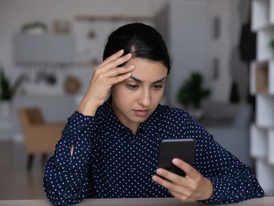 Pensive woman uses modern smartphone thinking 