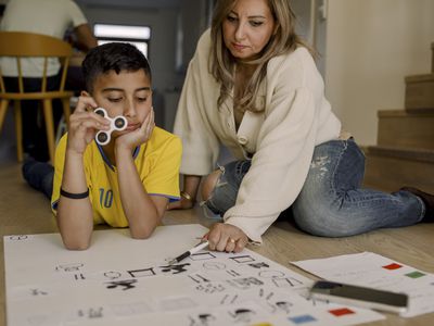 kid with a fidget spinner and a parent helping with their homework