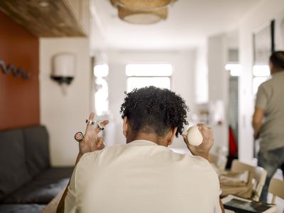 Rear view of teenager sitting at home