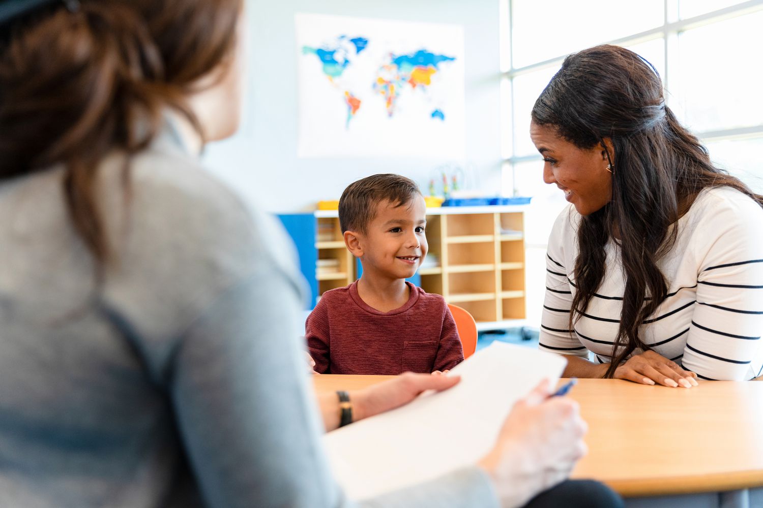 Child psychologist talks with young boy and his mom