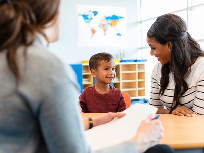 Child psychologist talks with young boy and his mom