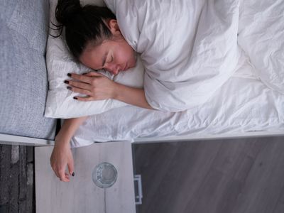 Woman sleeping near bedside table with water