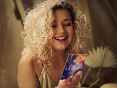 Meditative space in desert tent. Woman during soul journey with divination cards. Holding card and smiling