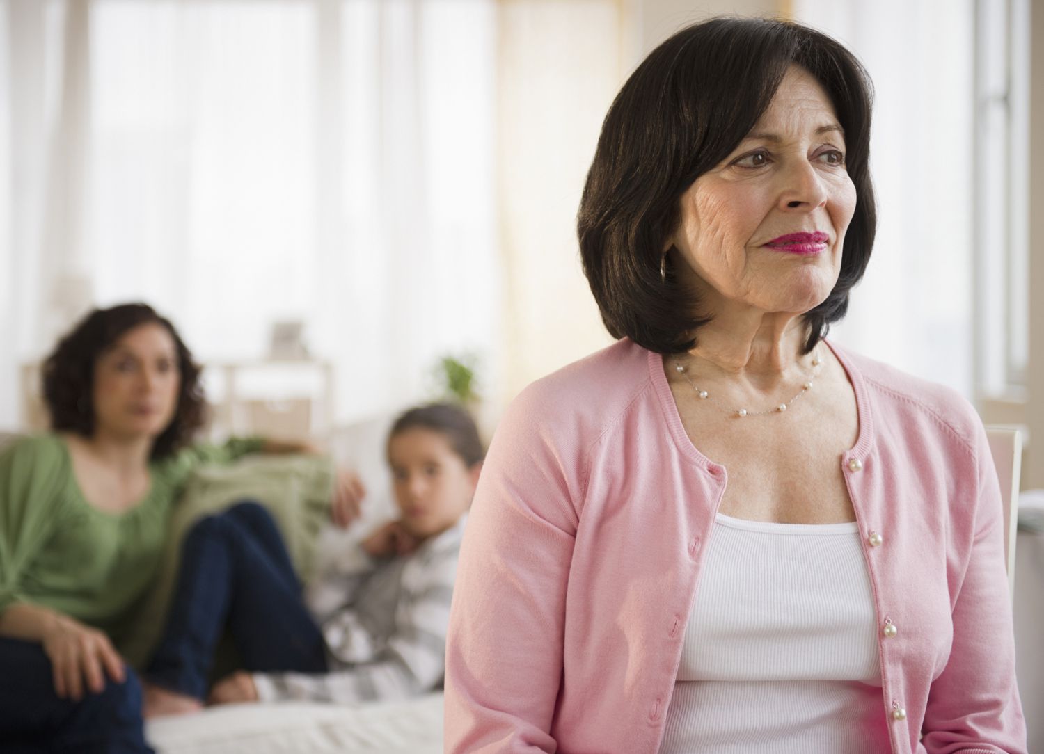 Serious mature woman with family in background