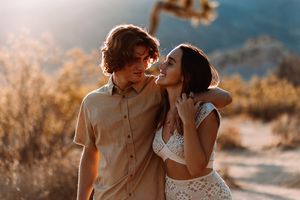 Young couple having fun holding each-other in a desert Oasis