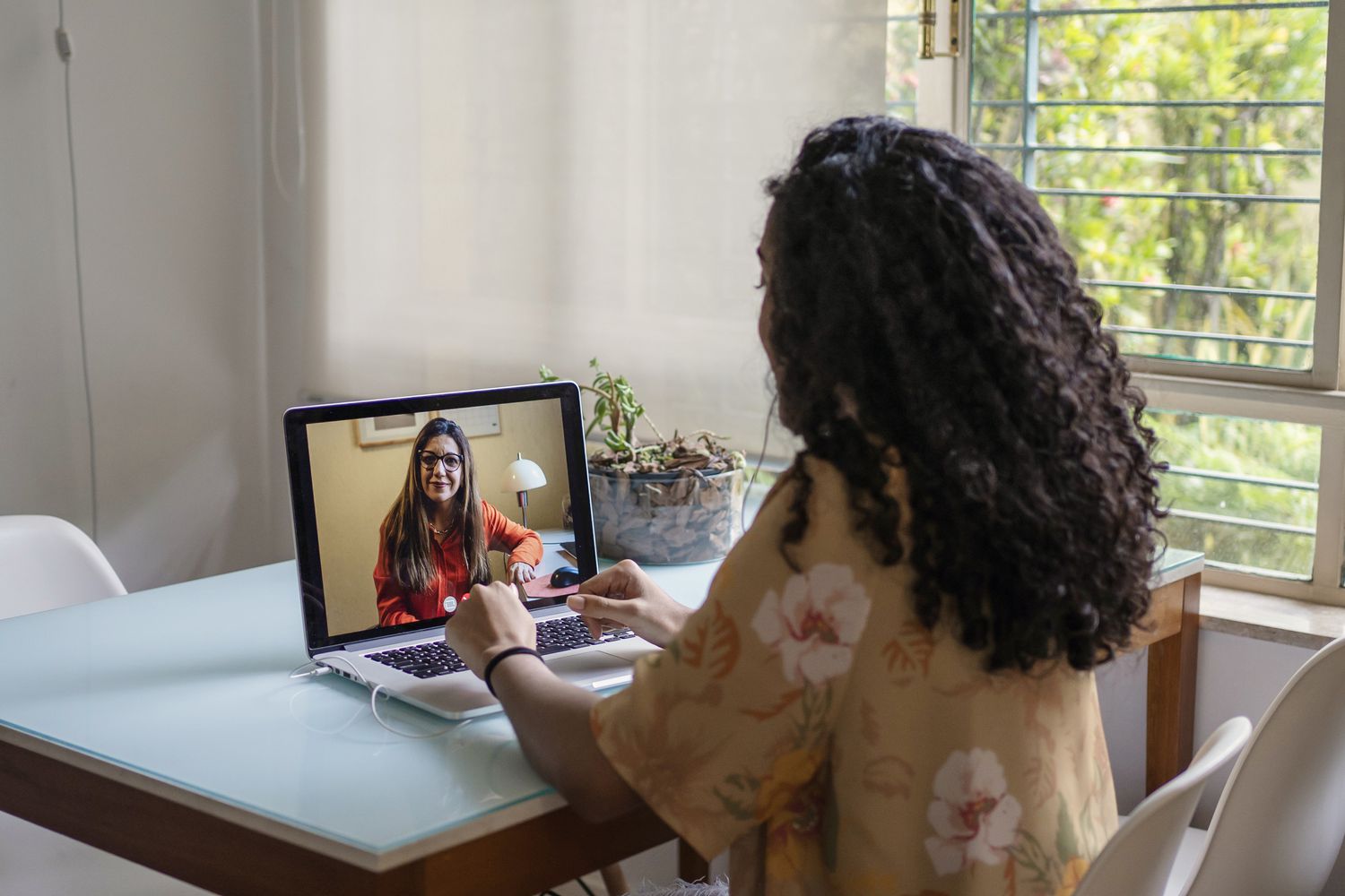 person doing online therapy near the window