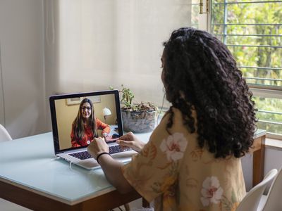 person doing online therapy at their desk next to the window