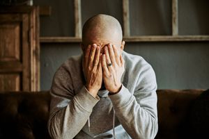 Adult man covering his face with both hands