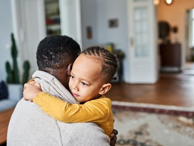 boy embracing father at home