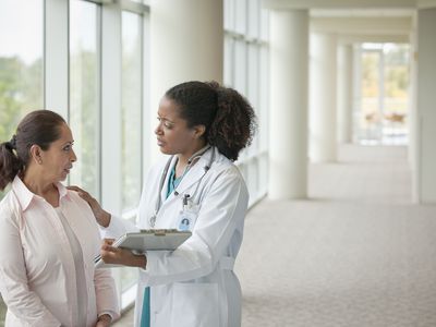 Doctors talking to woman in hospital