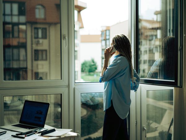 woman standing at the window and talking on the phone