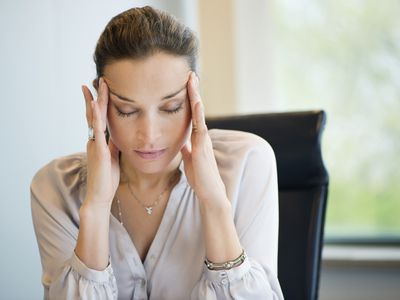 Close-up of a businesswoman suffering from a headache in an office