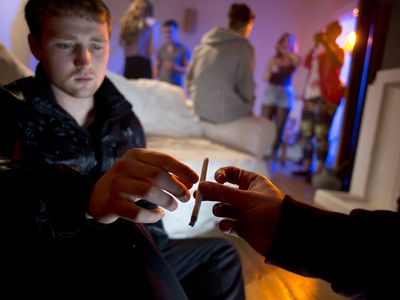 Young man hesitating to accept a joint at a house party