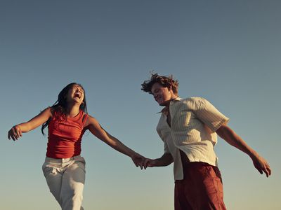 Low angle view of happy friends enjoying against clear blue sky