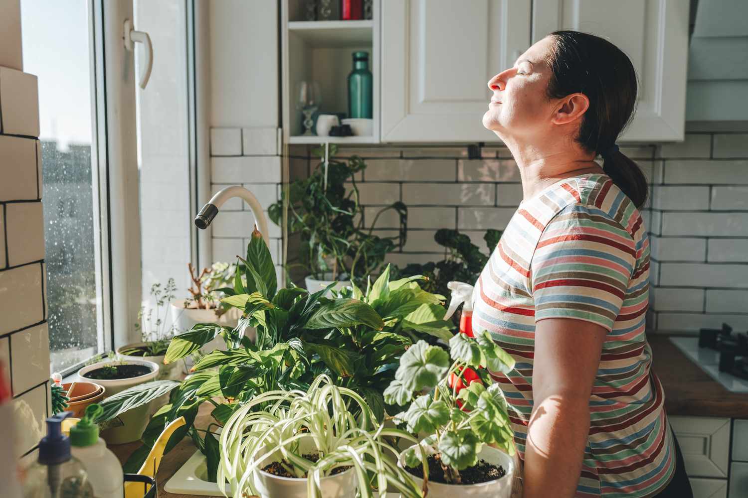 woman deep breathing exercises in own home garden among plants