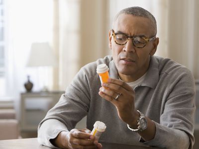 Man examining prescription bottles