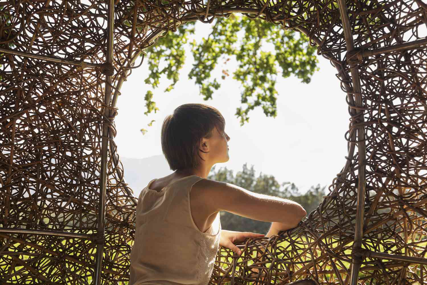 Woman looking out window of nest tree house 