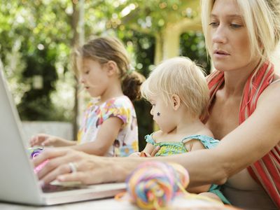 Mother multi tasking with children and laptop