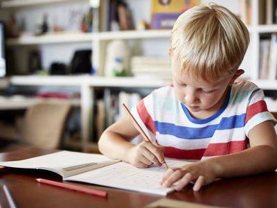 Young boy writing in workbook