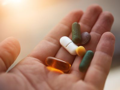 man hand holding his nutritional supplemets, healthy lifestyle background.