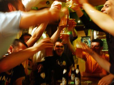 young men drinking beer and cheering