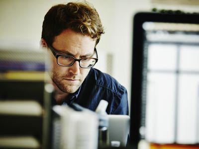 Businessman working on project on laptop in startup office