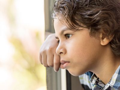 sad boy looking out the window