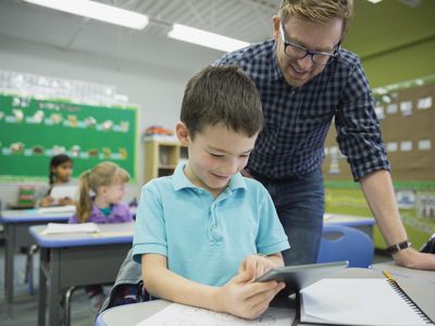 teacher helping student at desk