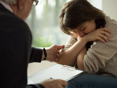 Close-up of psychologist comforting his depressed patient