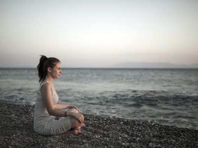 woman meditating at the beach