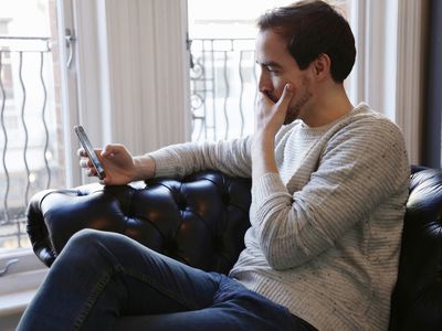 Man looking at his phone with a worried expression.