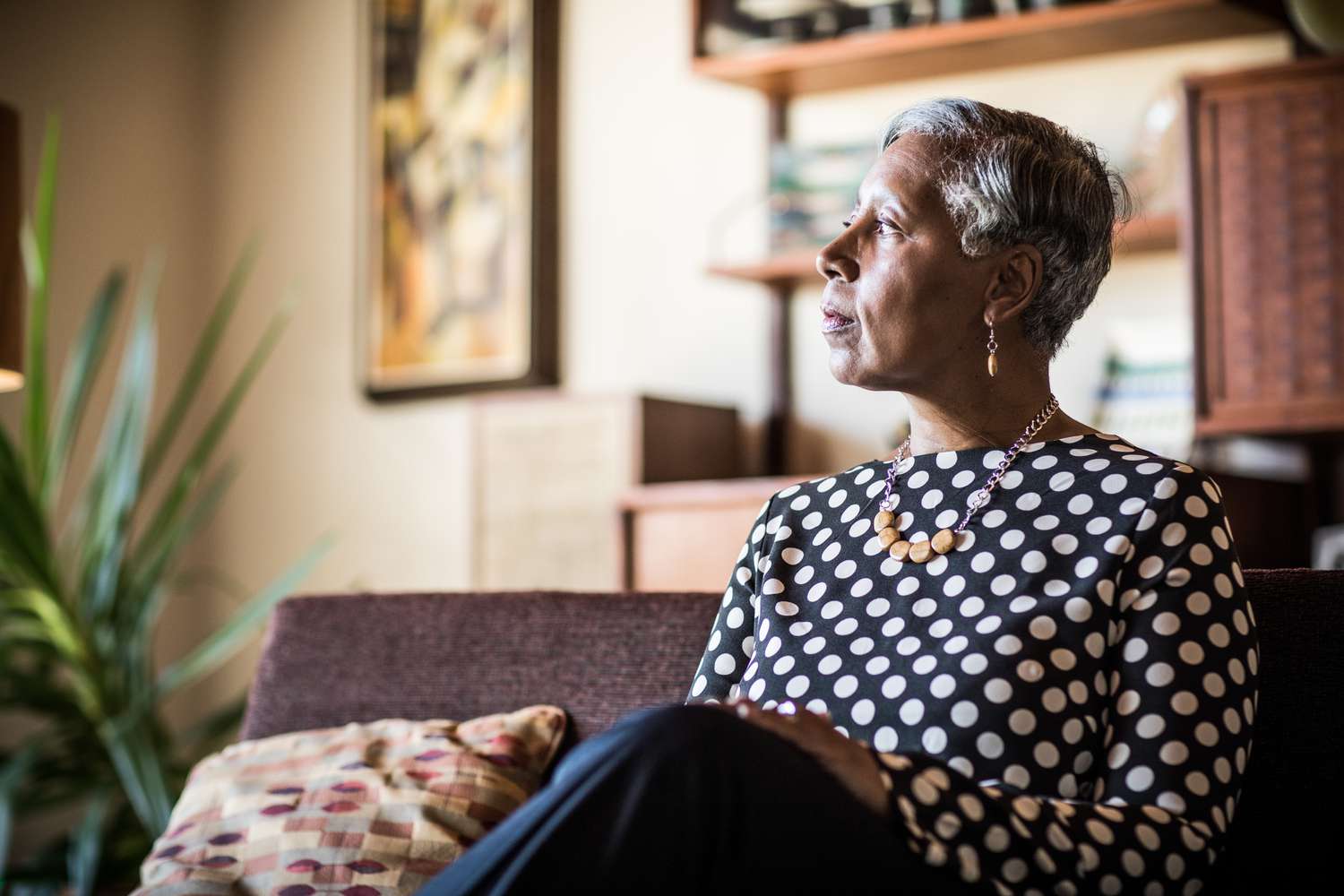 Portrait of woman (60yrs) sitting on couch at home