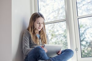 Candid Portrait of a Twelve Year Old Girl Using a Digital Tablet for Online Therapy.