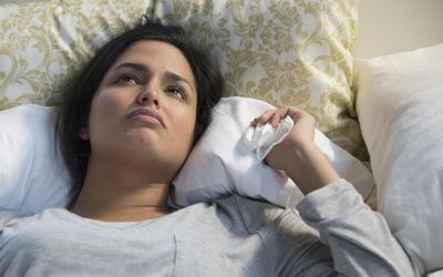 person depressed laying in bed