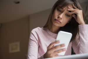 Frustrated woman texting on cell phone 