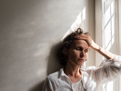 Tense woman leaning against a wall