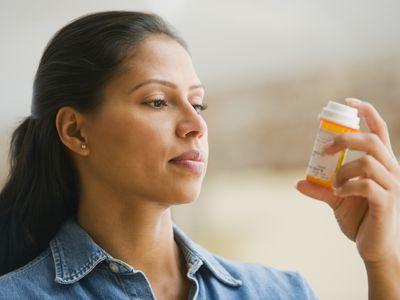 Hispanic woman reading medication