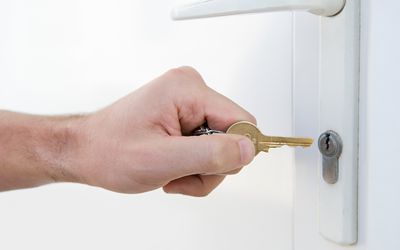 Man putting key into a lock