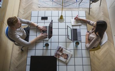 couple with laptops working at home