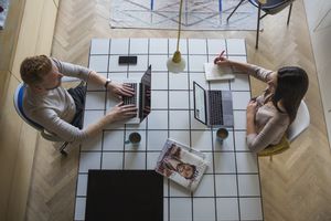 couple with laptops working at home