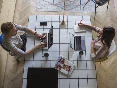 couple with laptops working at home