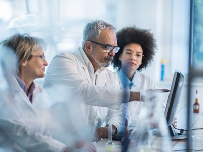 Three researchers in laboratory looking at computer screen