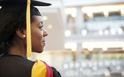 Woman in graduation gown looking away