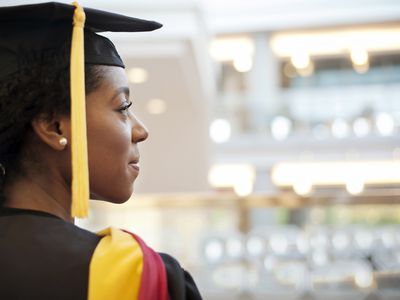 Woman in graduation gown looking away