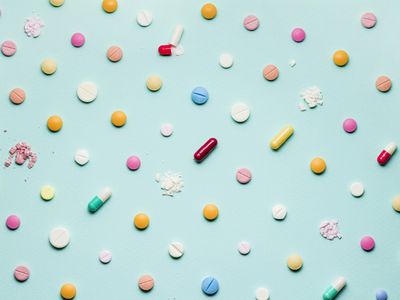 A photo of different medicinal drugs, tablets and pills on blue background.