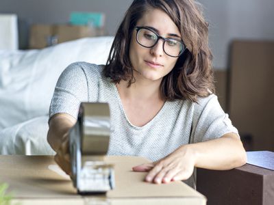 Woman taping a moving box