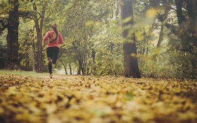 woman running in the forest on fallen leaves