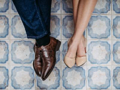 Top view of feet in formal shoes at nice, outdoor tiles.