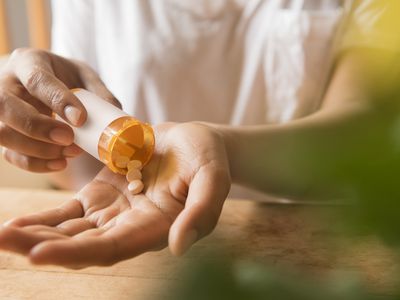 Hands of woman pouring prescription medicine in hand