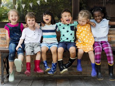 children sitting on a bench and smiling